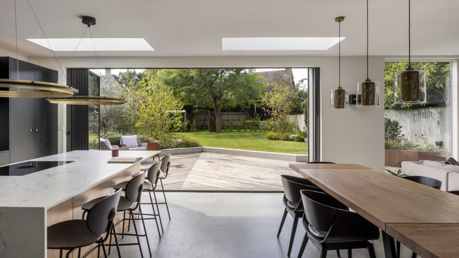 Premium aluminium bifold doors opening a contemporary kitchen onto a landscaped garden